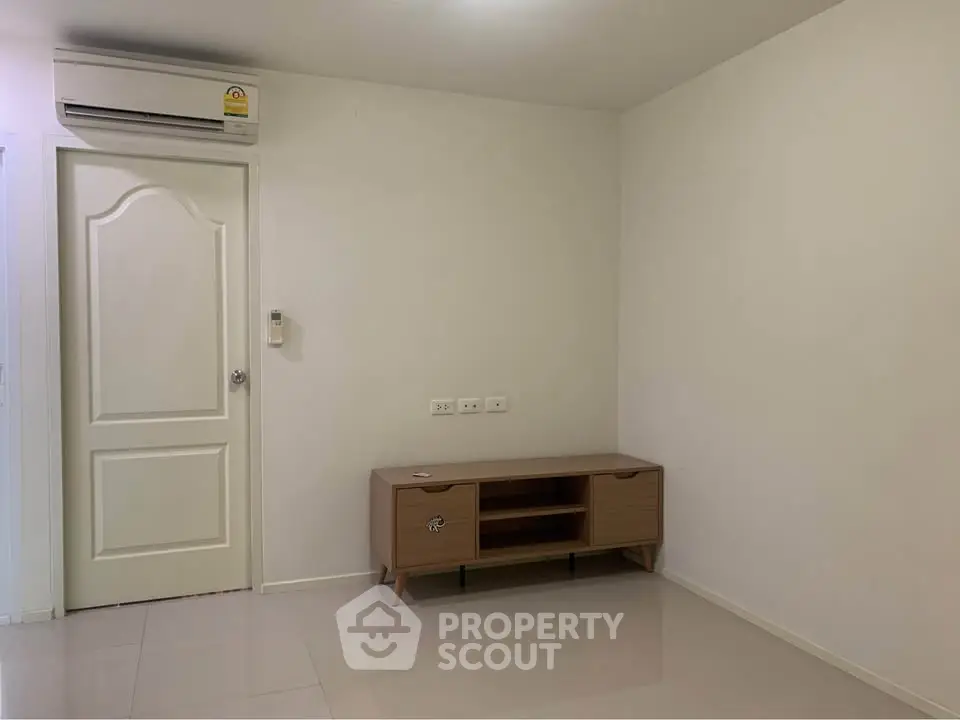 Minimalist living room with air conditioning and modern wooden cabinet.