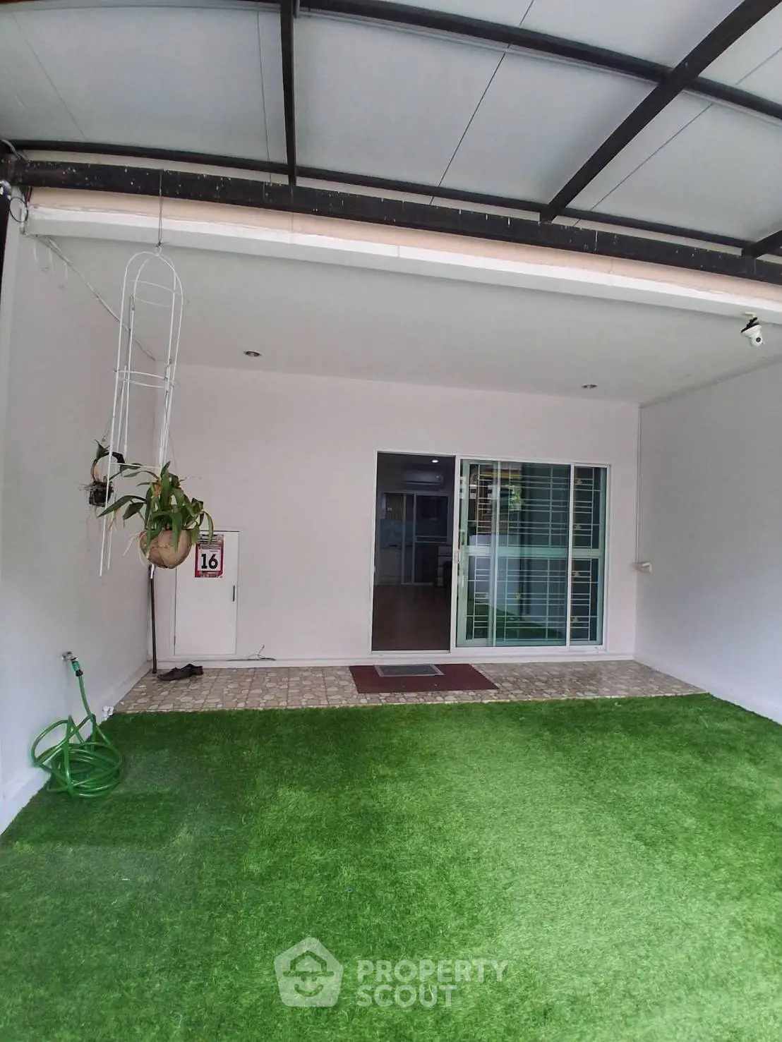 Charming home entrance with artificial grass and sliding glass doors, perfect for modern living.