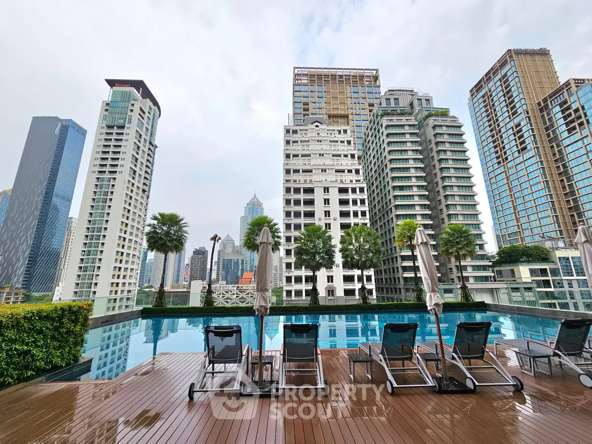 Luxurious rooftop pool with stunning city skyline views, perfect for relaxation and leisure in a high-rise urban setting.