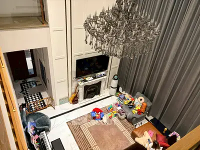 Luxurious living room with high ceiling, elegant chandelier, and modern decor