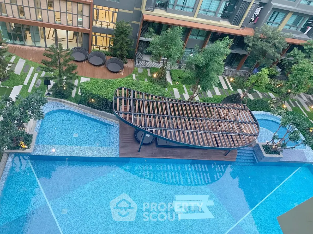 Luxurious apartment complex with stunning pool and lush garden view.