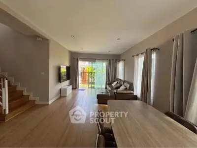 Spacious living room with modern decor and natural light, perfect for family gatherings.