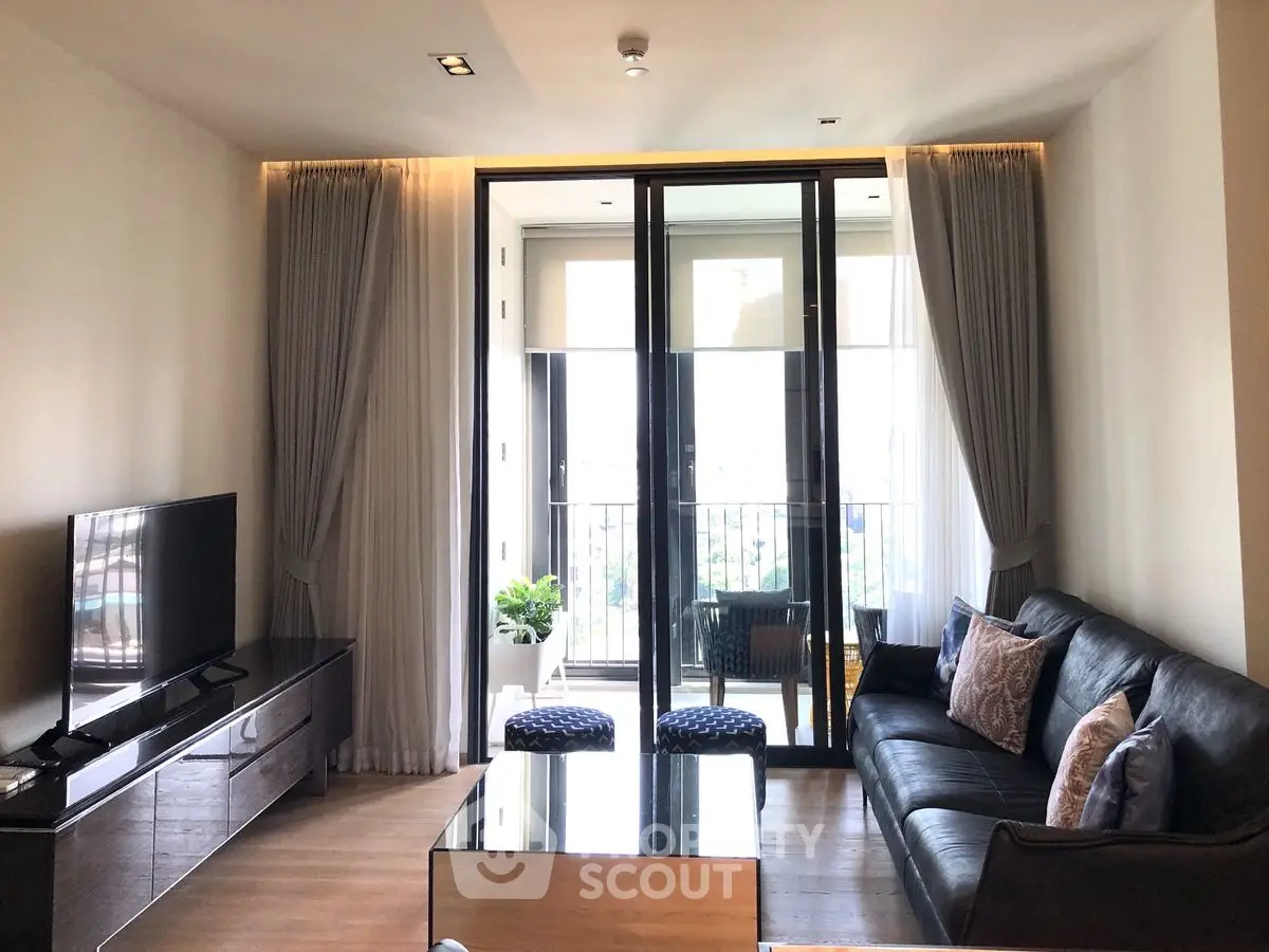 Modern living room with sleek furniture and balcony view, perfect for urban living.
