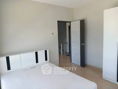 Spacious bedroom with modern design and natural light, featuring a minimalist aesthetic.