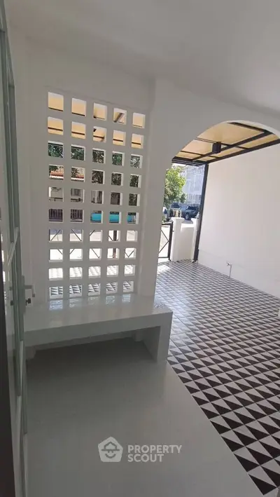 Charming covered balcony with stylish geometric floor tiles and open-air design.