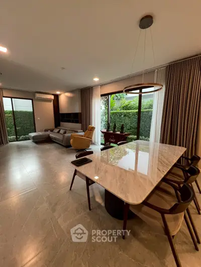 Spacious modern living room with elegant marble dining table and garden view.