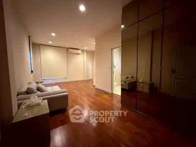 Spacious modern living room with wooden flooring and elegant furniture