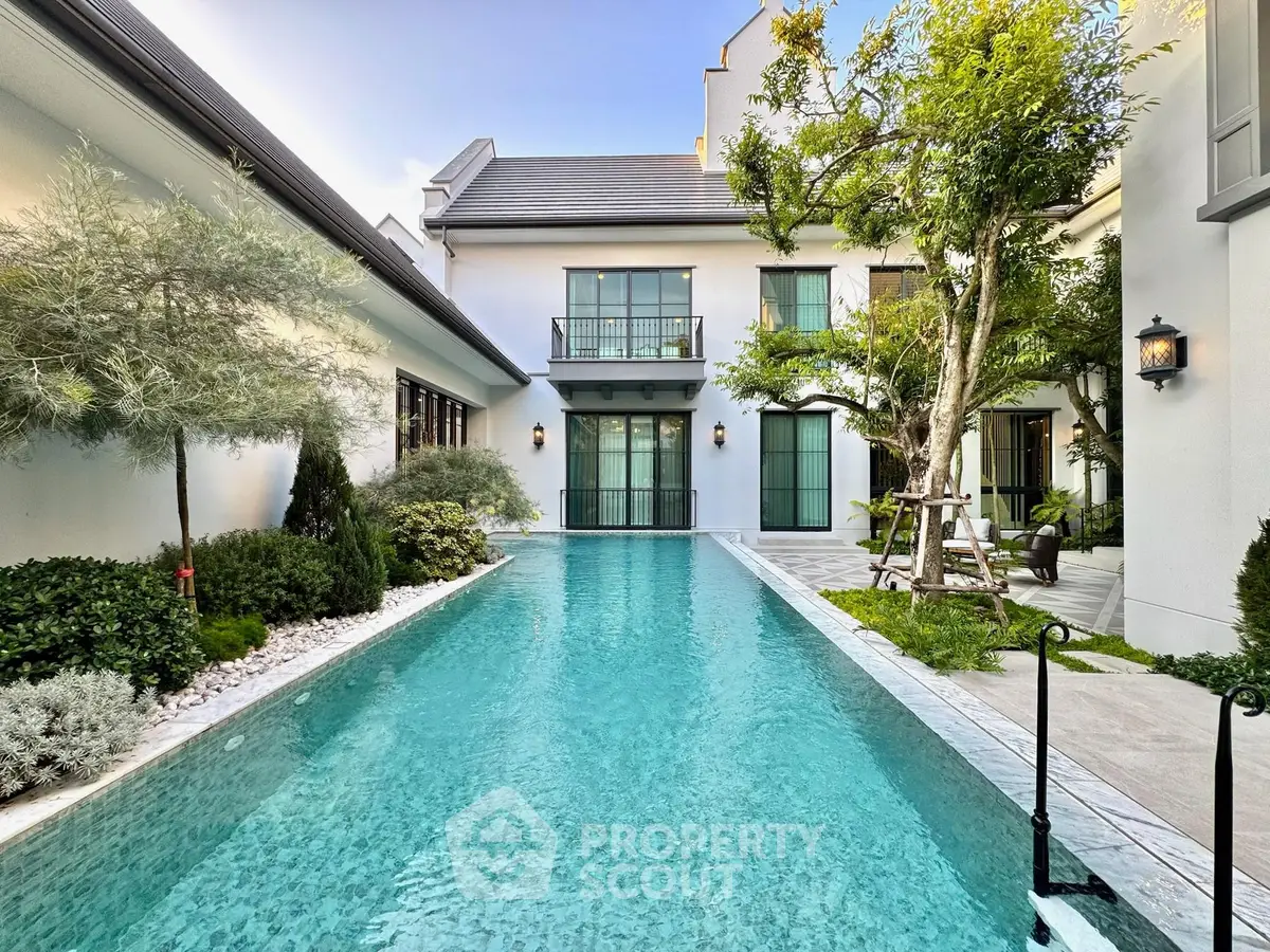 Luxurious modern home with stunning pool and lush garden, perfect for relaxation and entertainment.