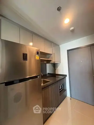 Modern kitchen with sleek cabinetry and stainless steel appliances in a compact layout.