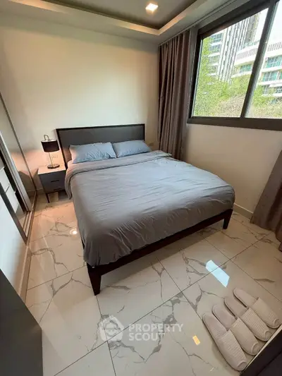 Modern bedroom with large window and sleek furnishings in urban apartment