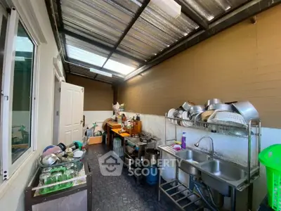 Spacious outdoor kitchen with ample storage and natural light, perfect for culinary enthusiasts.