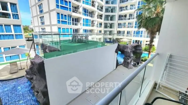 Modern apartment complex with pool and glass balcony, offering a luxurious lifestyle.