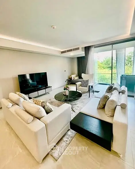 Spacious modern living room with elegant decor and large windows offering natural light.