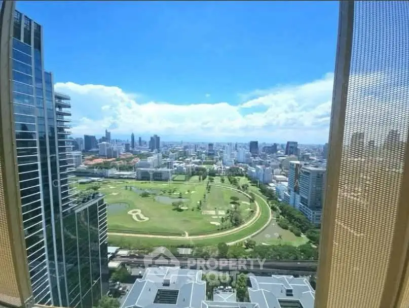 Stunning cityscape view from high-rise building with lush green park and skyline.