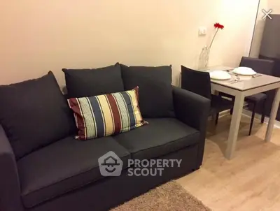 Cozy living room with dark sofa and modern dining table setup