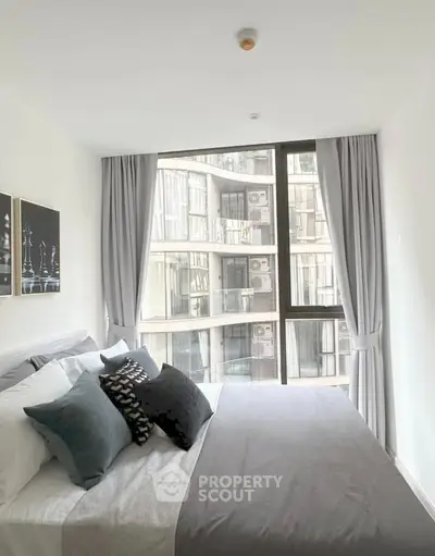 Modern bedroom with large windows and stylish decor in urban apartment