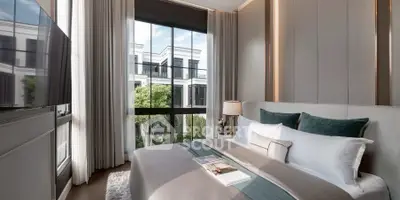 Luxurious bedroom with large window and elegant decor overlooking garden view