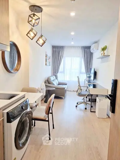 Modern living room with washing machine, stylish lighting, and work desk in a cozy apartment.