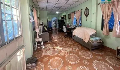 Spacious living room with patterned tile flooring and cozy furnishings in a well-lit home.