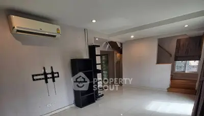 Spacious living room with modern air conditioning and sleek shelving, ideal for comfortable living.