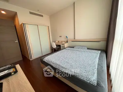 Modern bedroom with sleek furniture and large window offering natural light.