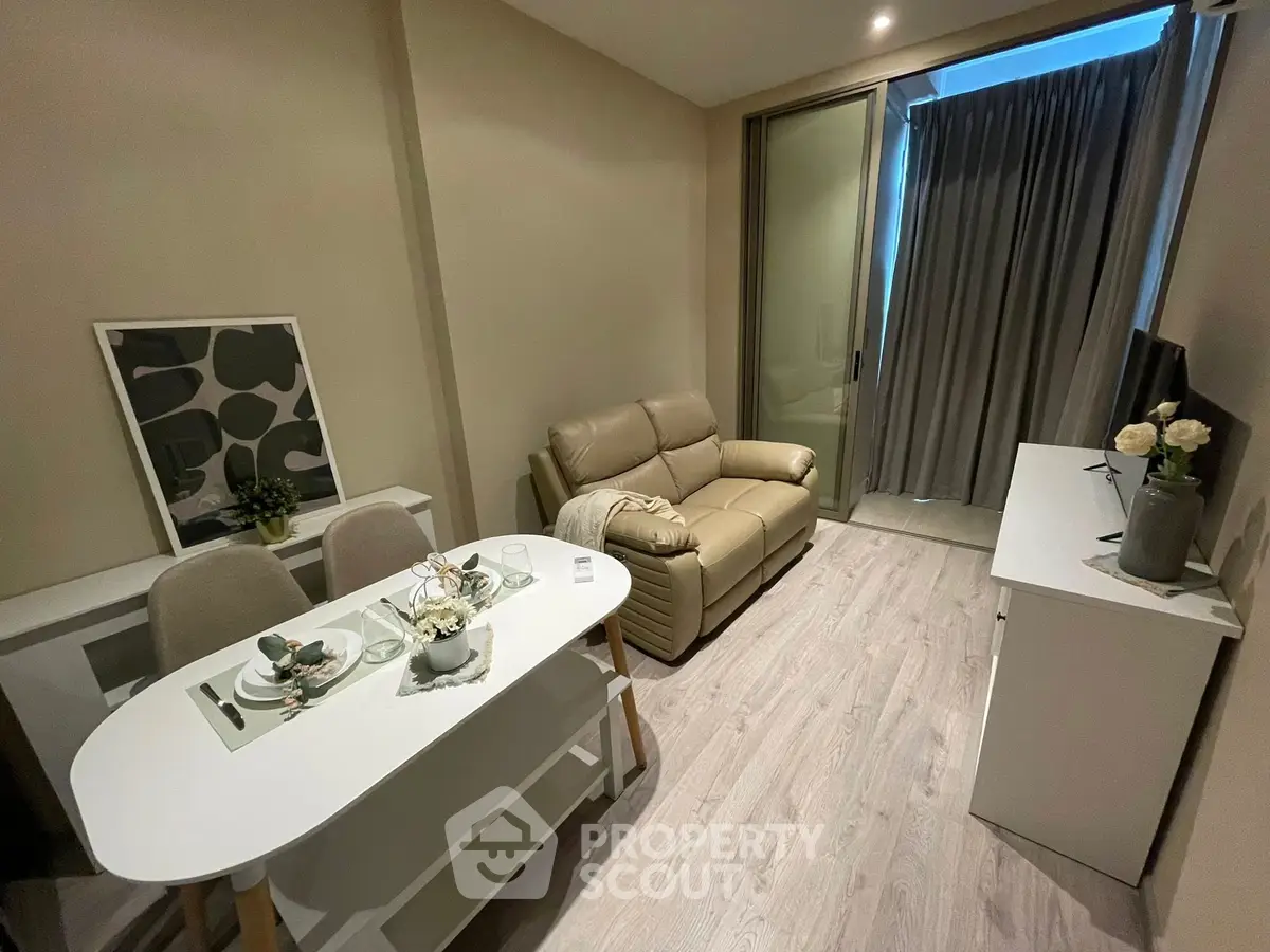 Modern living room with cozy sofa and dining area, featuring elegant decor and natural lighting.