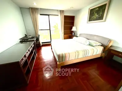 Spacious bedroom with wooden flooring and large window in modern apartment