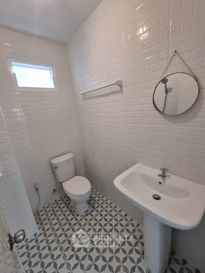 Modern bathroom with white subway tiles and geometric floor design