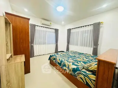 Spacious bedroom with modern decor and large windows in a stylish home.