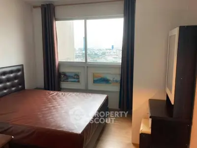 Cozy bedroom with large window offering city views, featuring a comfortable bed and stylish decor.