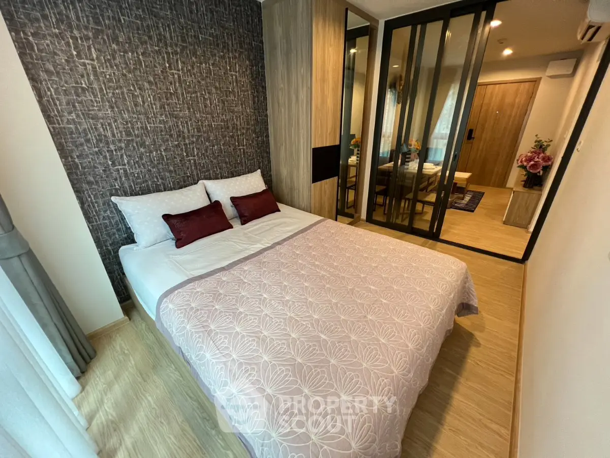 Cozy modern bedroom with stylish decor and mirrored wardrobe in a contemporary apartment.