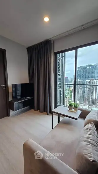 Modern living room with city view, featuring cozy sofa and wall-mounted TV, ideal for urban living.
