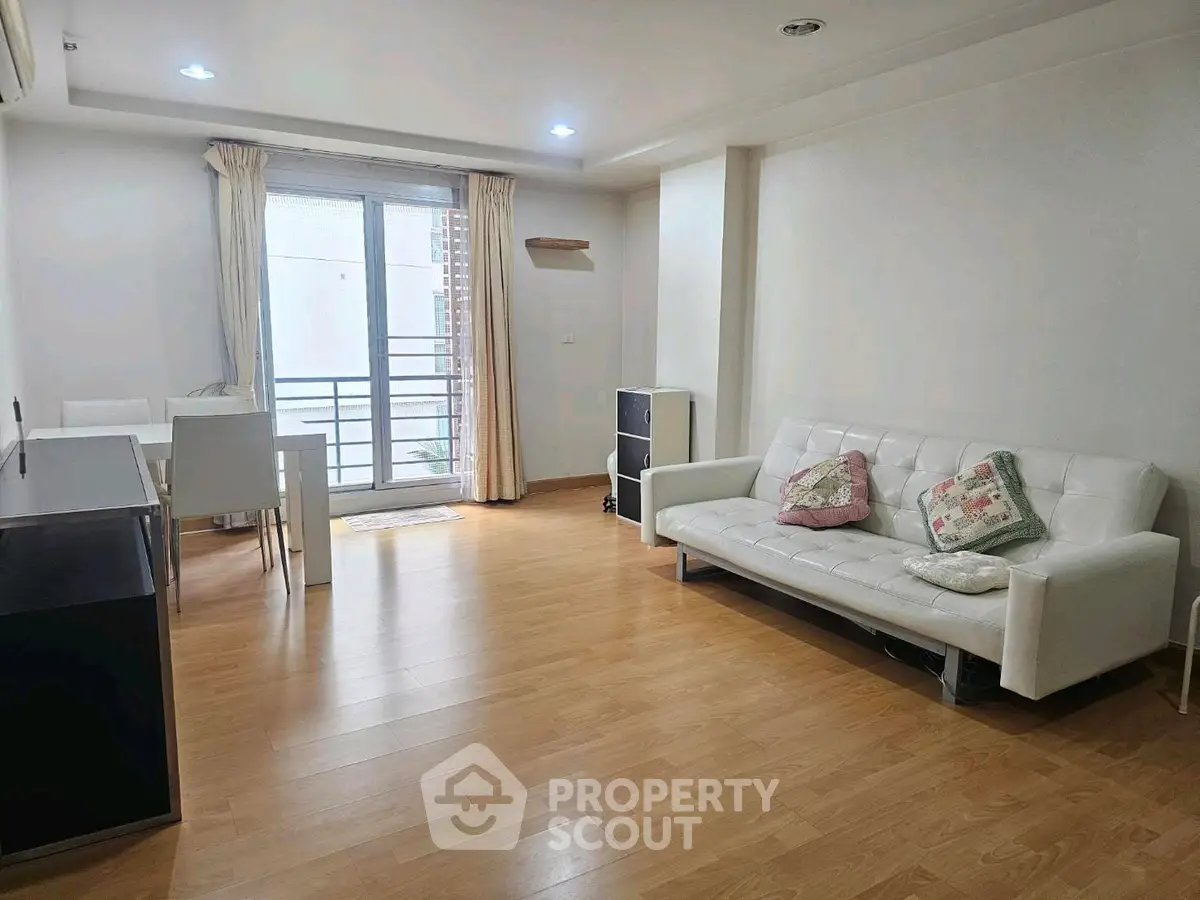 Spacious living room with modern decor and balcony access in a stylish apartment.
