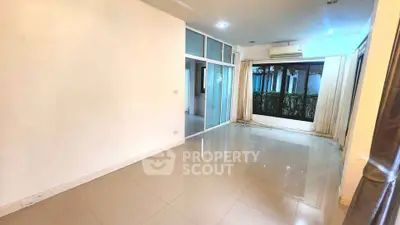 Spacious living room with large window and tiled flooring in modern apartment