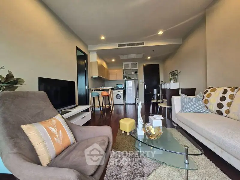 Modern living room with open kitchen, stylish furniture, and cozy ambiance