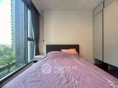 Modern bedroom with large window and city view, featuring sleek wardrobe and cozy bed.