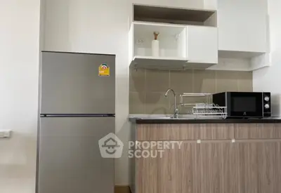 Modern kitchen with stainless steel fridge and microwave in sleek apartment