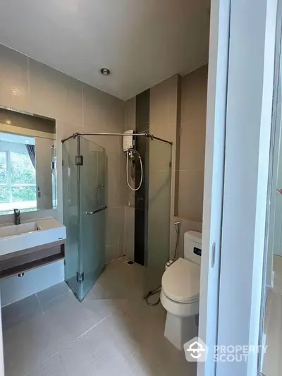 Modern bathroom with glass shower and sleek fixtures in bright apartment