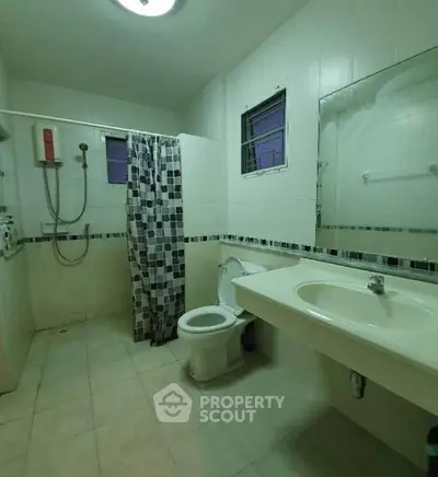 Spacious bathroom with shower and modern fixtures in a well-lit setting.