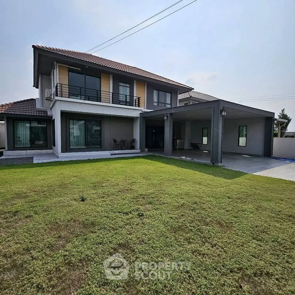 Spacious two-story house with large lawn and modern design, perfect for family living.