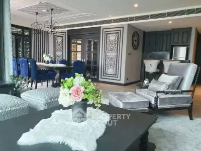 Luxurious living room with elegant decor and open kitchen layout, featuring plush seating and stylish dining area.