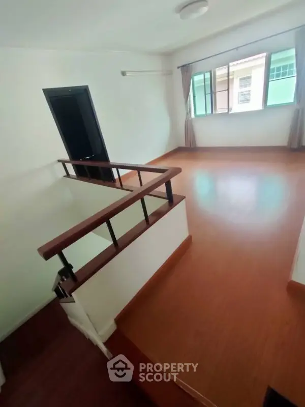 Spacious unfurnished room with wooden flooring and large window
