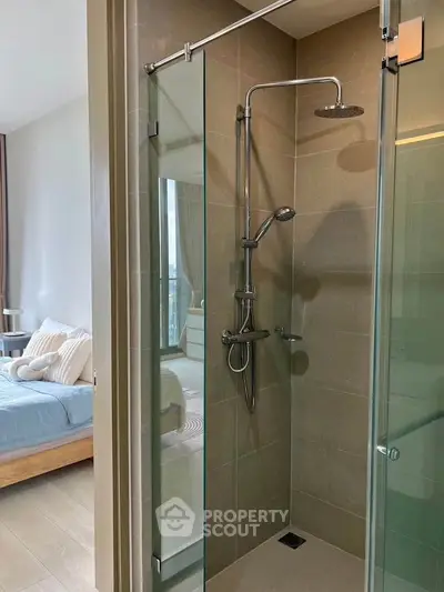 Modern bathroom with glass shower and view into cozy bedroom