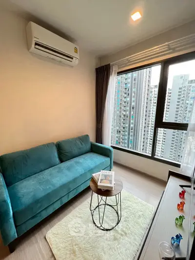 Modern living room with teal sofa and city view from large window