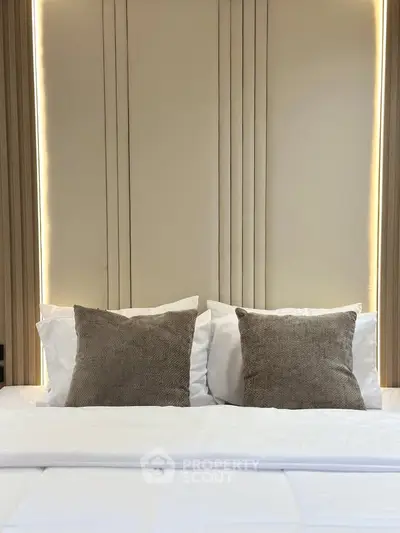 Luxurious bedroom with elegant lighting and plush pillows, perfect for relaxation and comfort.