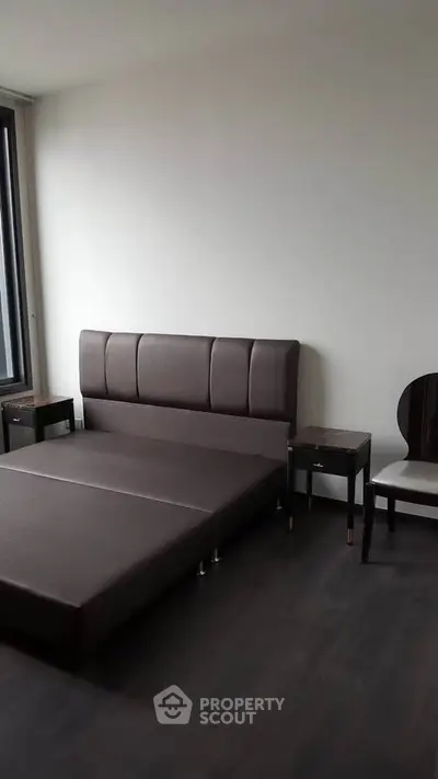 Modern minimalist bedroom with sleek furniture and large window