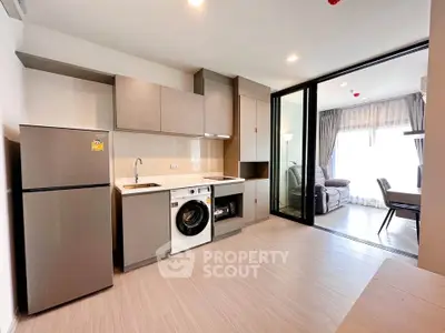 Modern kitchen with washing machine and open layout leading to living room