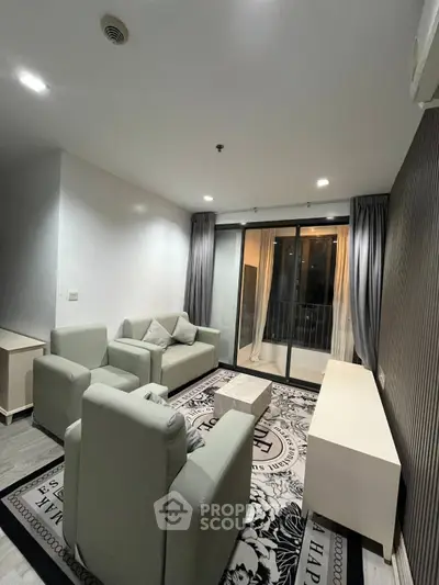 Modern living room with stylish furniture and large windows leading to a balcony, perfect for relaxation.