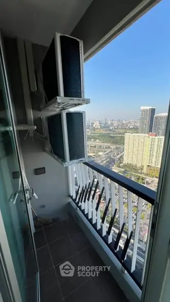 High-rise balcony with city view and air conditioning units, perfect for urban living.