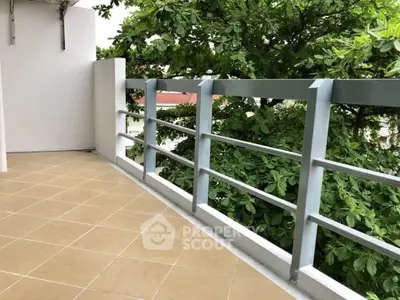 Spacious balcony with lush green view and modern railing design